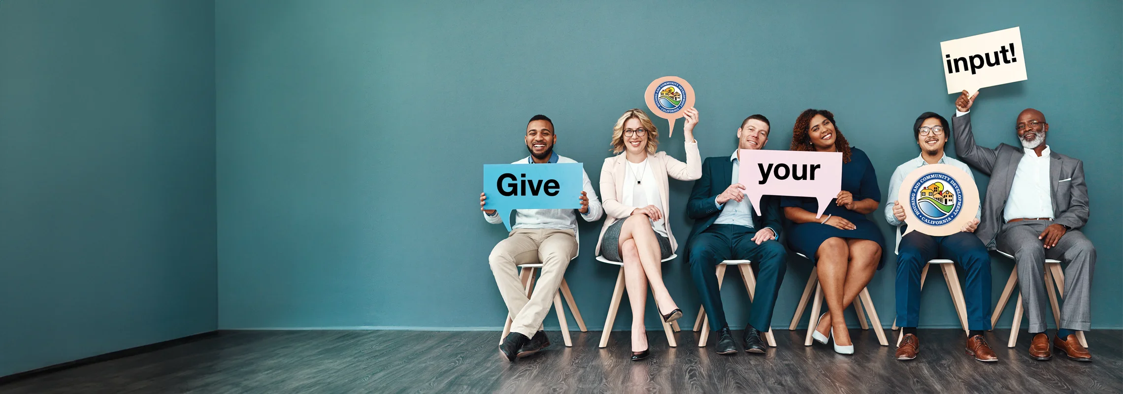 People holding signs that read "Give Your Input."