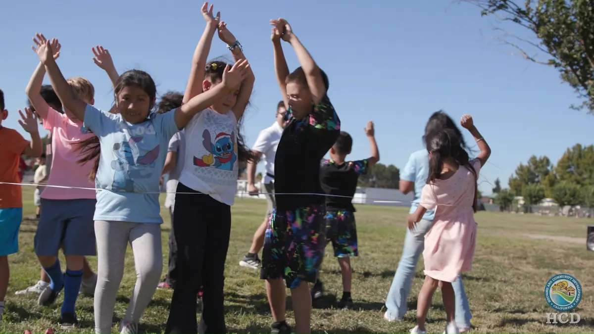 children playing in a circle with their hands up