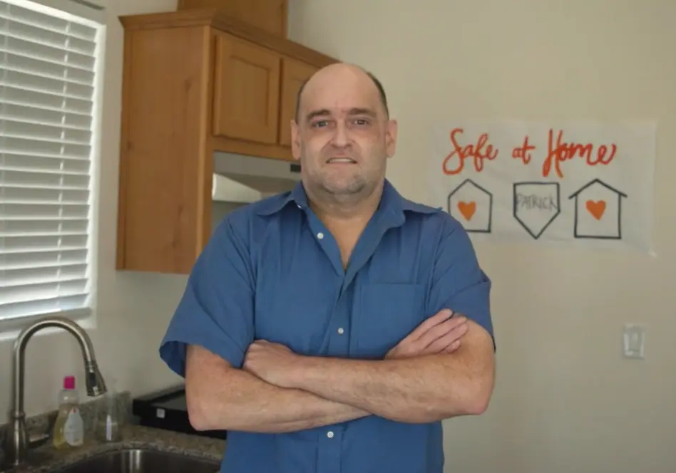 Resident Patrick smiling in his kitchen